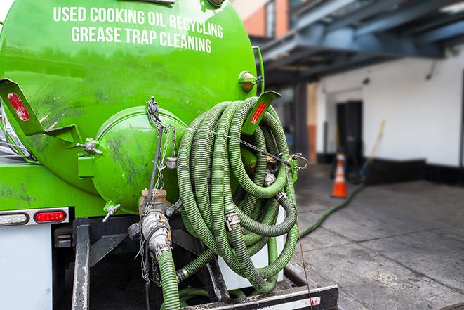 a grease trap being pumped by a sanitation technician in Gilbertsville